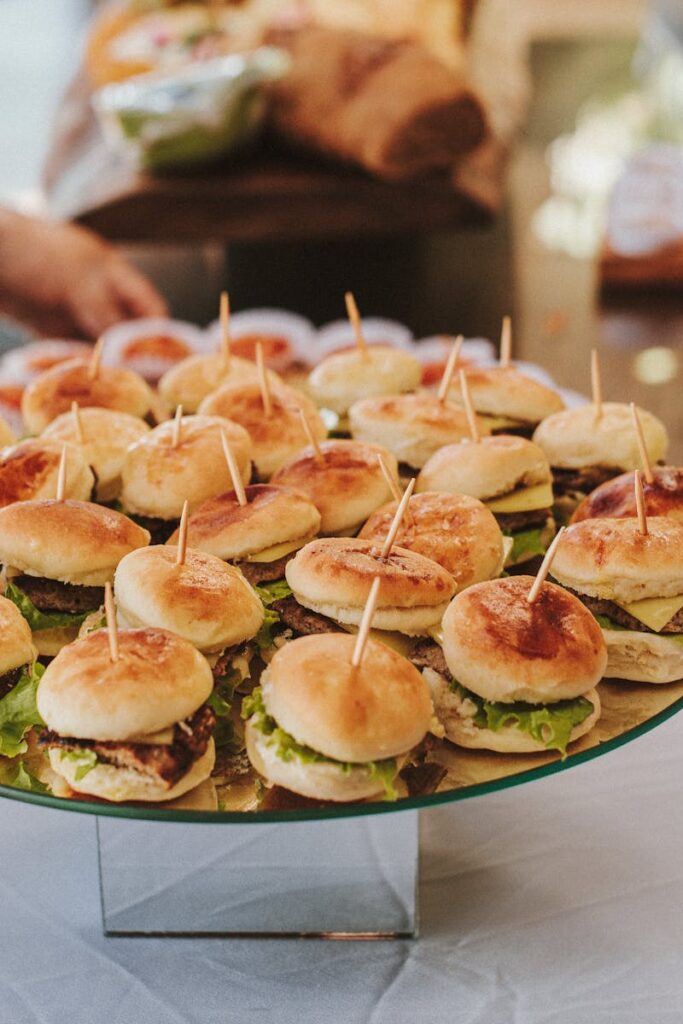 A close-up view of mini burgers on skewers at a buffet table, perfect for events and gatherings.