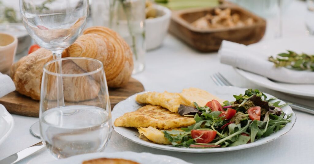 Cozy outdoor brunch setting with omelette and wine glasses on a floral tablecloth.