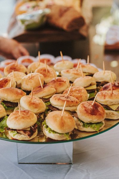 A close-up view of mini burgers on skewers at a buffet table, perfect for events and gatherings.