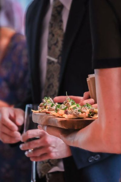 A waiter serving gourmet appetizers at a formal banquet, highlighting elegant dining.