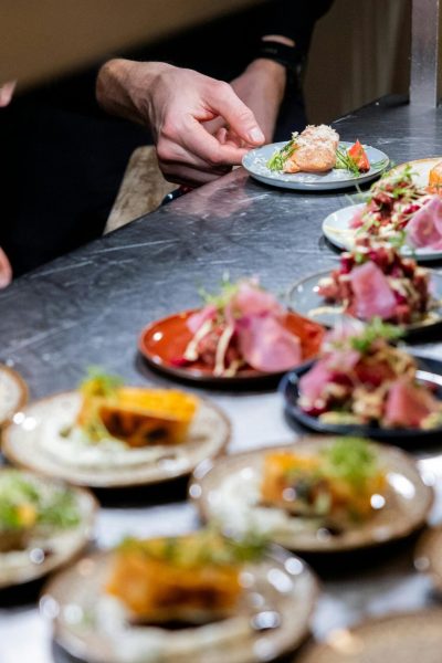 Chefs expertly plate gourmet dishes at a culinary event in Hamburg, showcasing vibrant colors and textures.